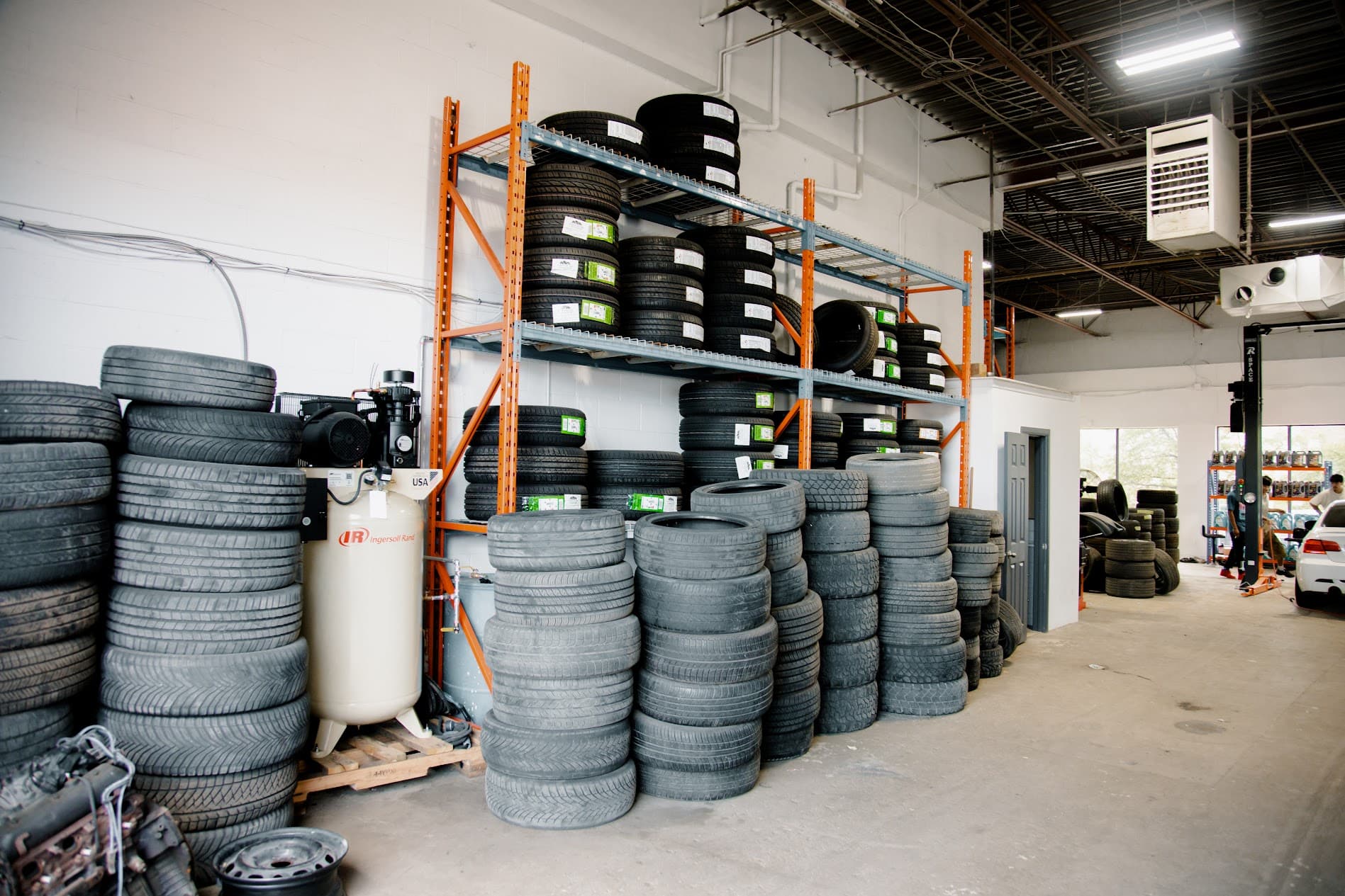 Heavy-duty tire inventory racking and industrial Ingersoll Rand air compressor