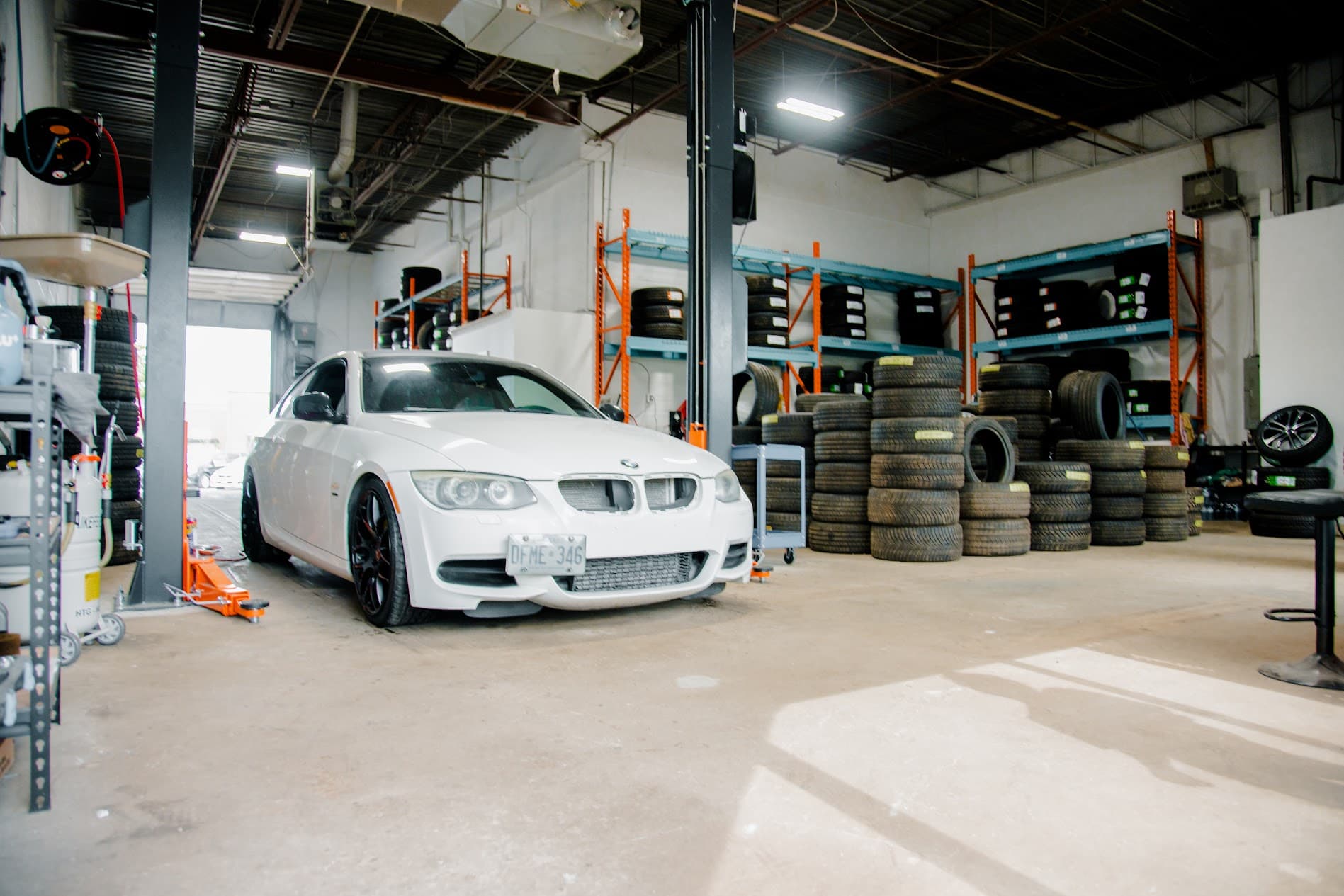 Full workshop floor overview featuring service bays and organized tire inventory